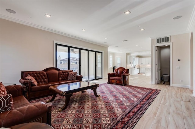 living room with crown molding and light hardwood / wood-style flooring