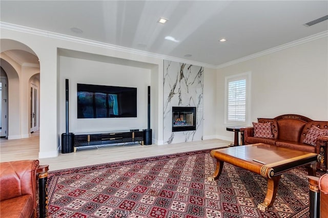 living room featuring ornamental molding and a fireplace