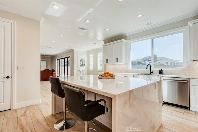 kitchen featuring light stone countertops, dishwasher, a kitchen island, white cabinetry, and sink