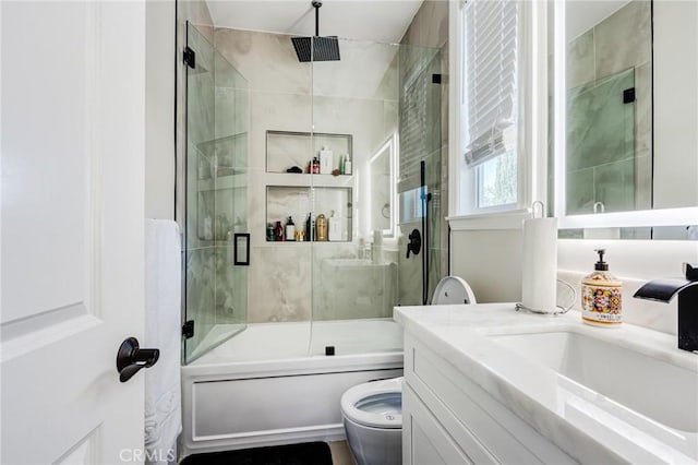 full bathroom with toilet, vanity, and bath / shower combo with glass door