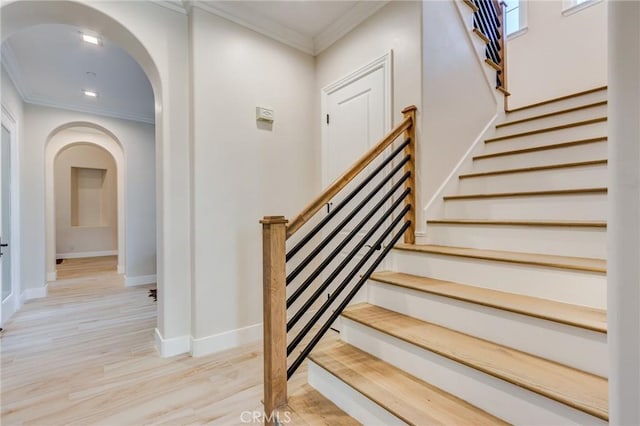 stairs featuring ornamental molding and wood-type flooring