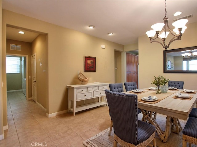 dining area featuring light tile patterned floors and an inviting chandelier