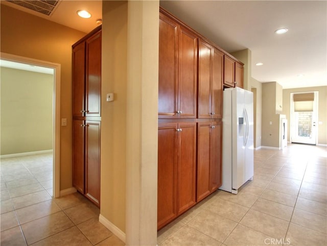 kitchen with light tile patterned floors and white fridge with ice dispenser