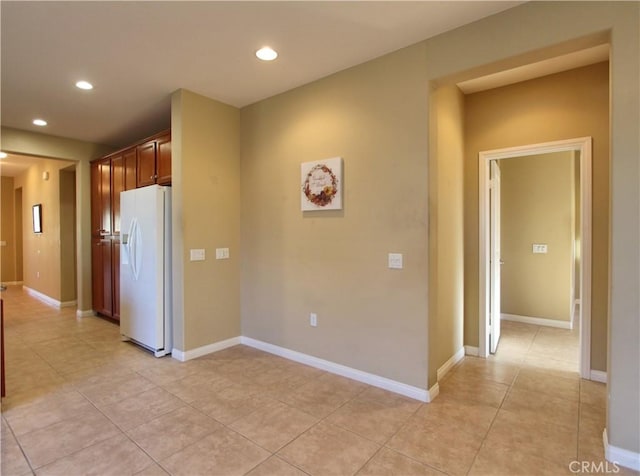 kitchen featuring light tile patterned floors and white refrigerator with ice dispenser