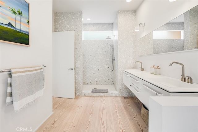 bathroom with vanity, hardwood / wood-style flooring, and tiled shower