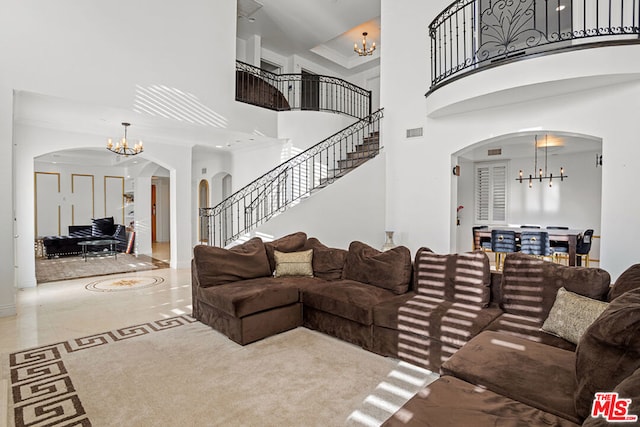 living room featuring a high ceiling, crown molding, and an inviting chandelier