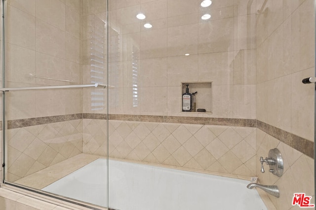 bathroom with combined bath / shower with glass door