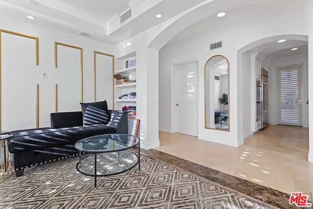 sitting room featuring built in shelves and ornamental molding