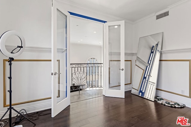 exercise room with dark hardwood / wood-style flooring, ornamental molding, and french doors