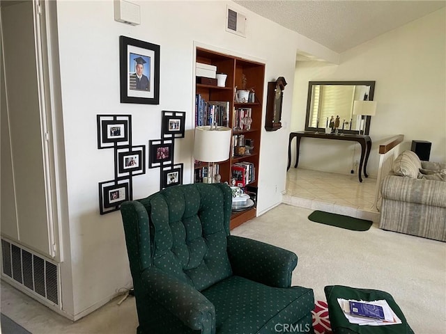 sitting room featuring a textured ceiling and lofted ceiling