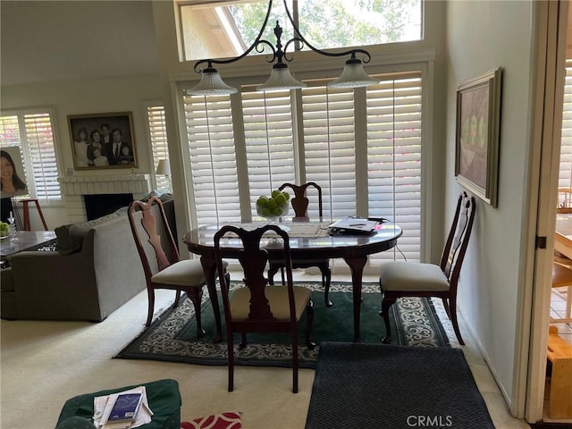 carpeted dining area with a fireplace