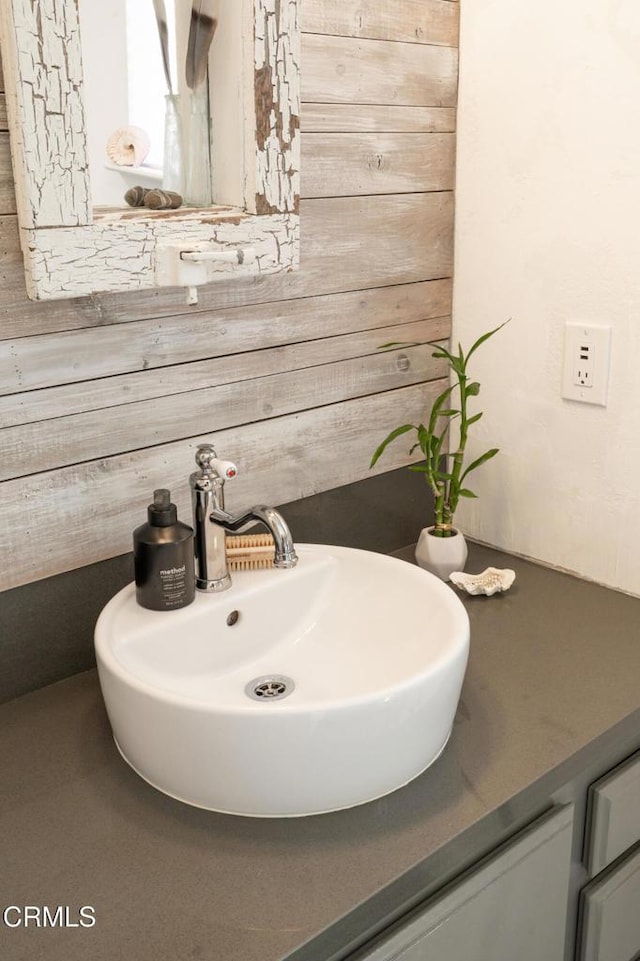 bathroom with vanity and wood walls