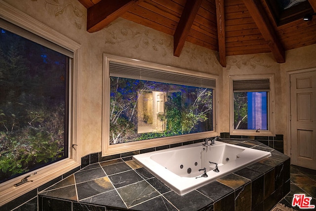 bathroom featuring wood ceiling, beamed ceiling, and a relaxing tiled tub