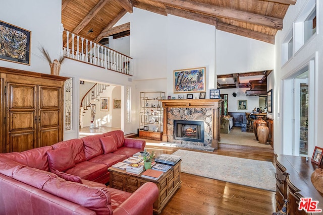 living room featuring wooden ceiling, beam ceiling, hardwood / wood-style floors, and high vaulted ceiling