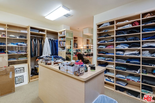 walk in closet with light carpet