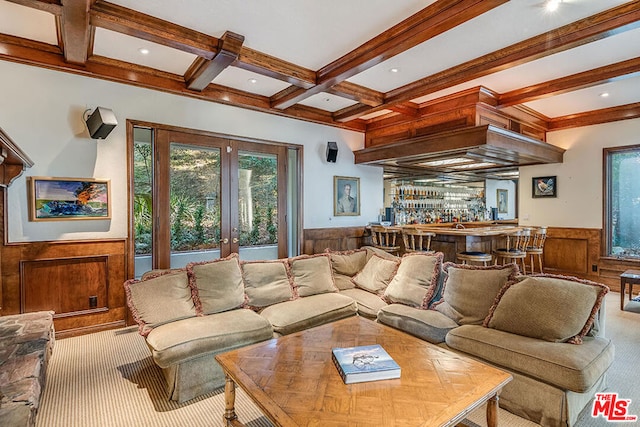 carpeted living room with french doors, wooden walls, beamed ceiling, bar area, and coffered ceiling