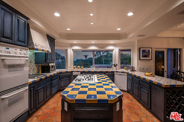 kitchen featuring custom exhaust hood, double wall oven, wooden counters, dishwasher, and a center island