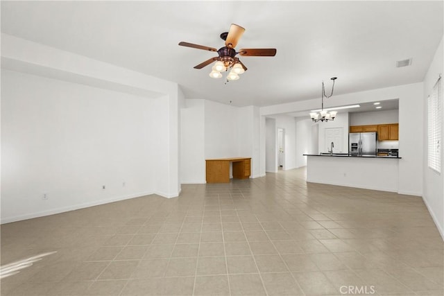 unfurnished living room with ceiling fan with notable chandelier and light tile patterned flooring