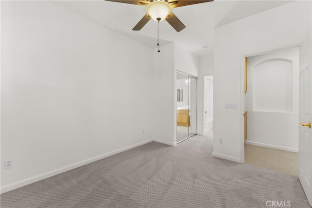 unfurnished bedroom featuring ceiling fan, a closet, and light carpet