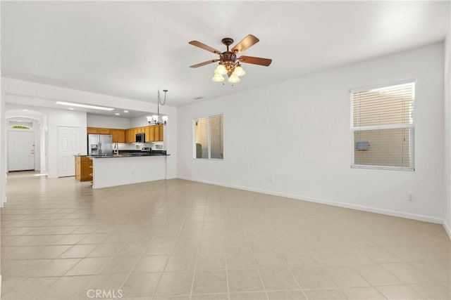 unfurnished living room featuring ceiling fan with notable chandelier and light tile patterned floors