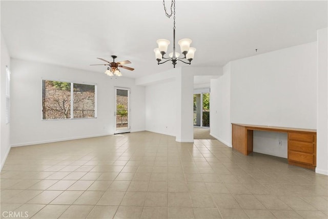 tiled empty room featuring a wealth of natural light and ceiling fan with notable chandelier