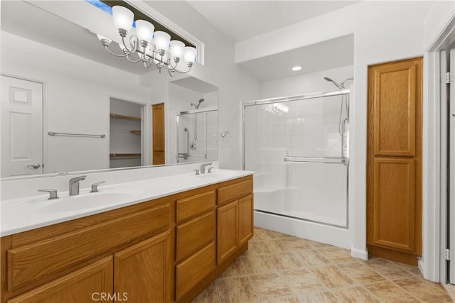 bathroom featuring vanity, an enclosed shower, and a notable chandelier