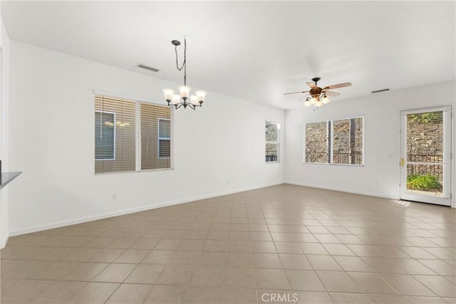 tiled spare room featuring ceiling fan with notable chandelier