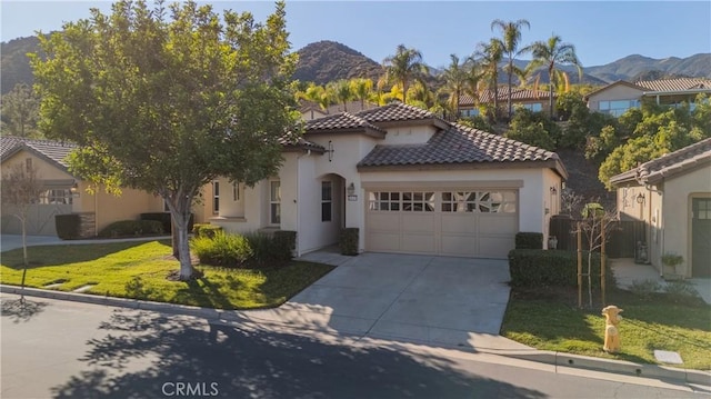 mediterranean / spanish-style home with a front lawn, a mountain view, and a garage