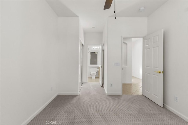 unfurnished bedroom featuring ceiling fan, connected bathroom, and light carpet