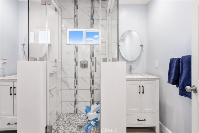 bathroom featuring a shower with shower door and vanity