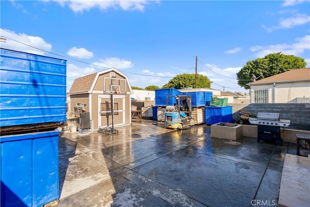 view of patio / terrace with a grill and a storage unit