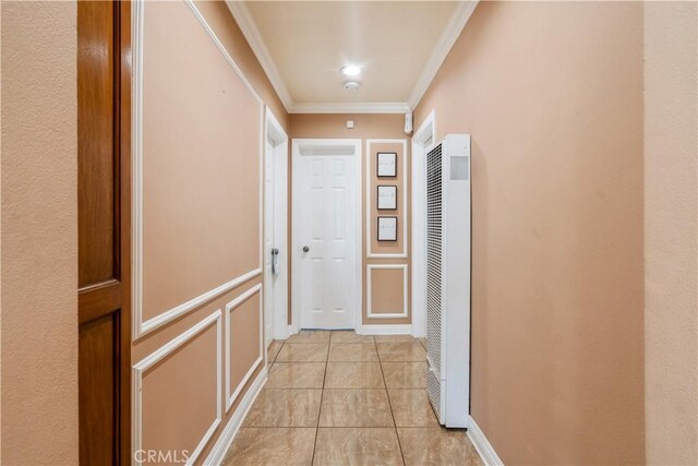 hallway with light tile patterned floors and ornamental molding