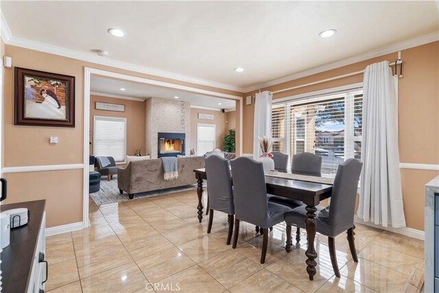 dining space featuring a fireplace and crown molding