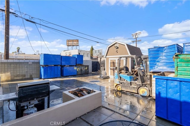 view of patio / terrace featuring a storage shed and a fire pit