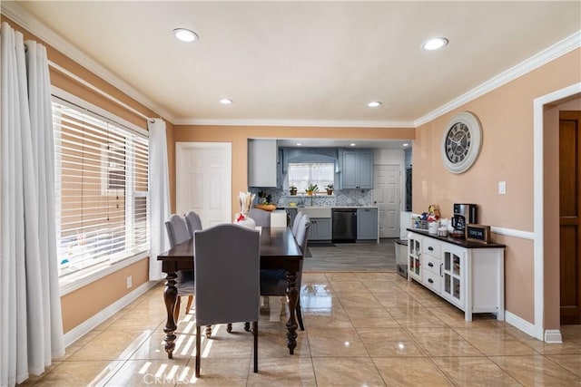 tiled dining space featuring sink, a wealth of natural light, and crown molding