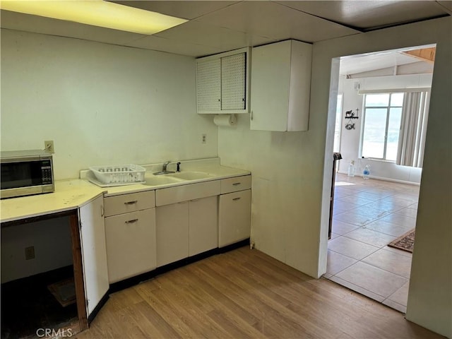 kitchen featuring light hardwood / wood-style floors, sink, and white cabinets