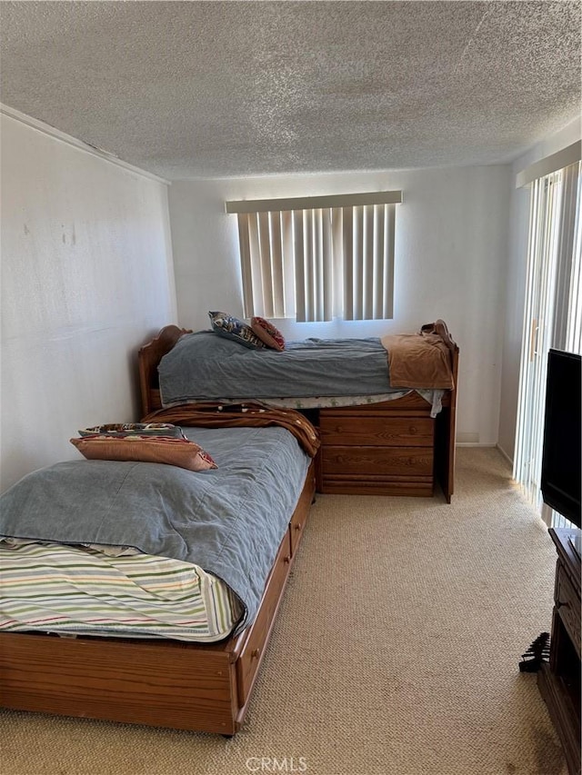 bedroom with light carpet and a textured ceiling