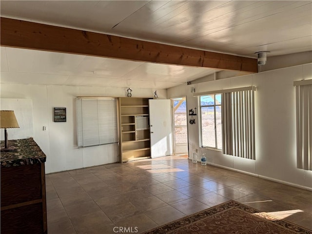 unfurnished room with dark tile patterned floors, lofted ceiling with beams, and wood ceiling