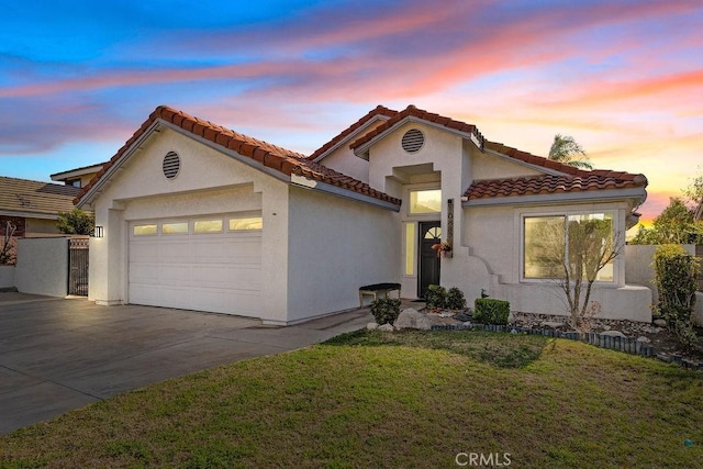 mediterranean / spanish home featuring a garage and a lawn