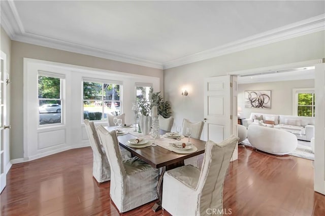 dining area featuring ornamental molding and dark hardwood / wood-style flooring