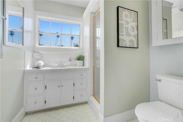 bathroom featuring toilet, vanity, tile patterned flooring, and an enclosed shower