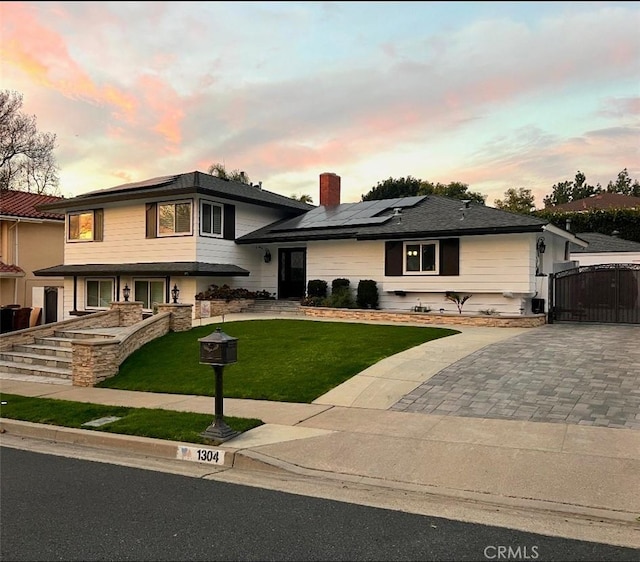 view of front of house featuring a lawn and solar panels