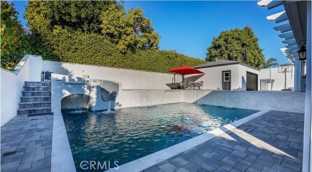 view of pool with a patio and pool water feature