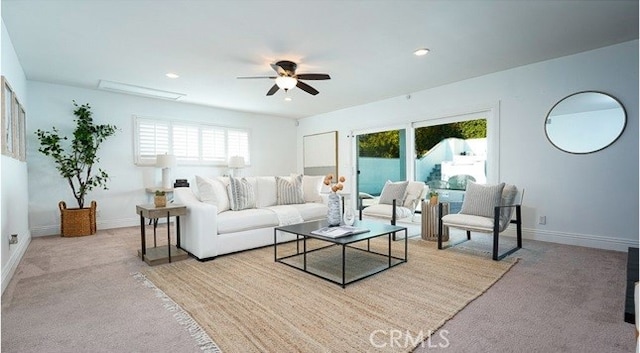 carpeted living room with ceiling fan