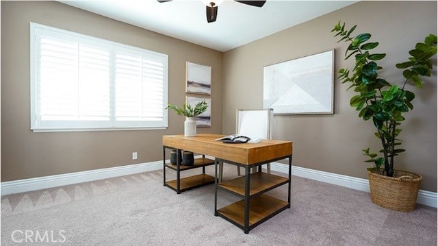 carpeted home office featuring ceiling fan