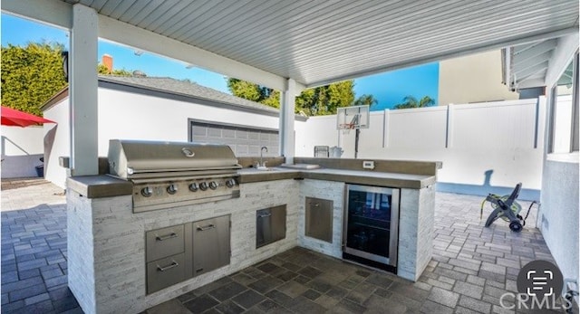 view of patio / terrace featuring wine cooler, a grill, sink, and an outdoor kitchen