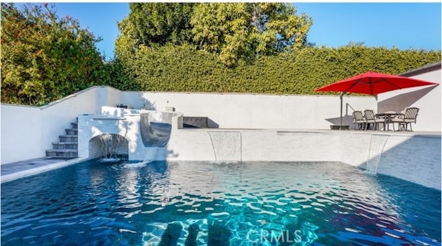 view of pool featuring pool water feature and a patio