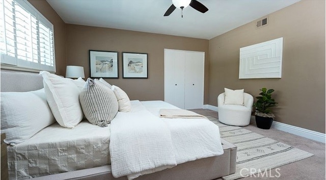 bedroom with light carpet, a closet, and ceiling fan