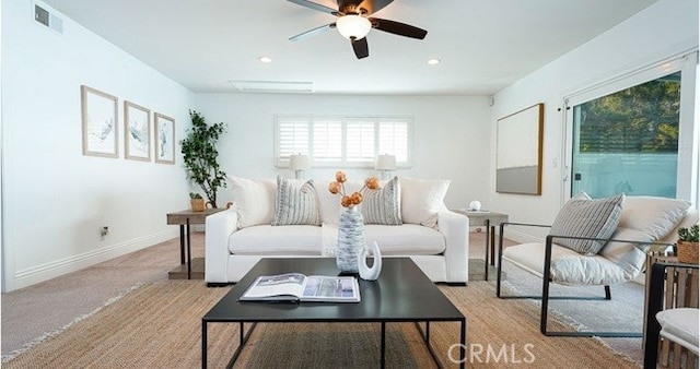 carpeted living room with ceiling fan