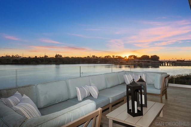 patio terrace at dusk featuring a water view